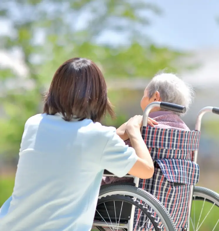 スタッフが車椅子の利用者に寄り添いサポートしている様子