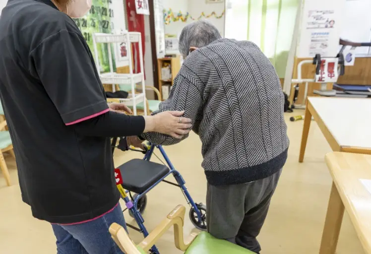スタッフが利用者の歩行を支えている様子