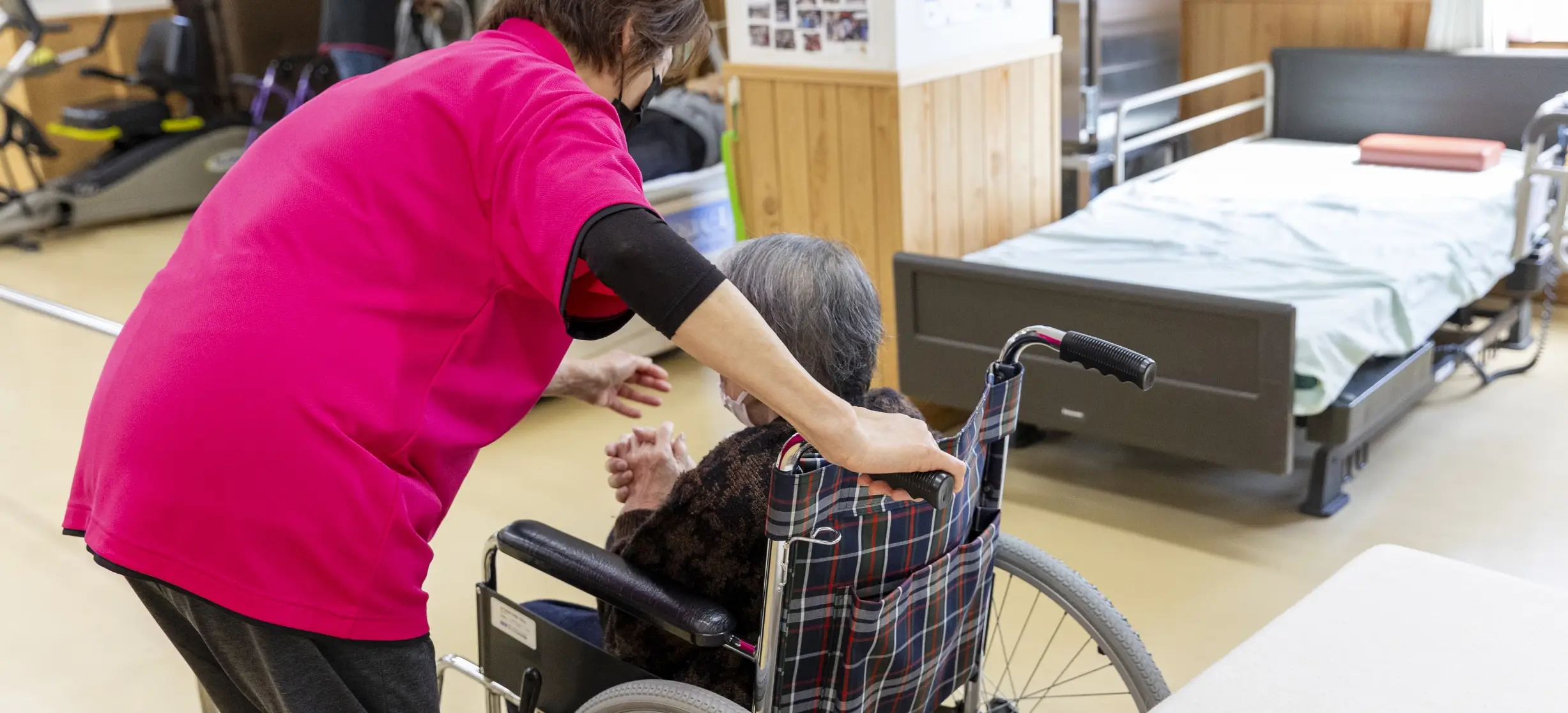 スタッフが車椅子の利用者をサポートしている様子