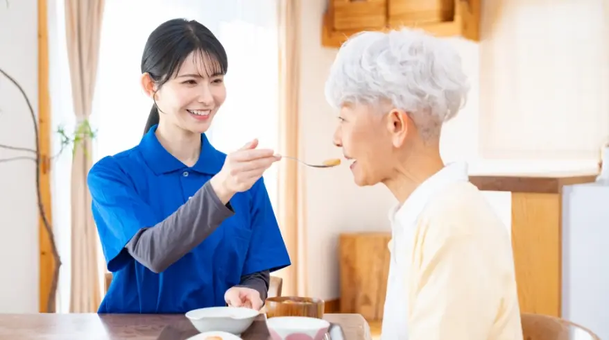 スタッフが住宅を訪問し食事をサポートしている様子